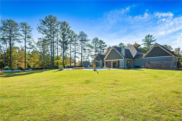 rear view of house with a lawn and fence