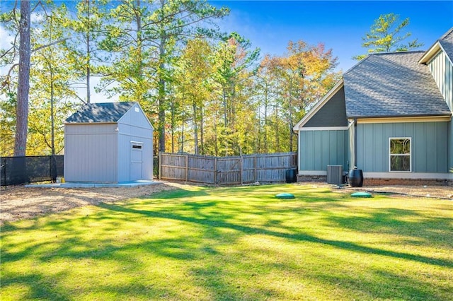 view of yard with central AC unit, a storage unit, an outdoor structure, and a fenced backyard