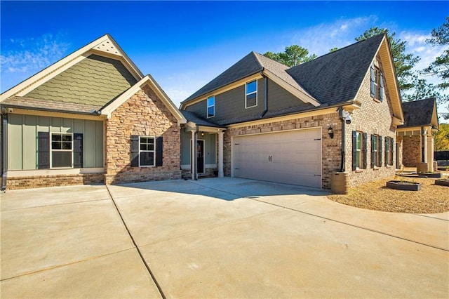 craftsman-style home with brick siding, a shingled roof, an attached garage, board and batten siding, and driveway