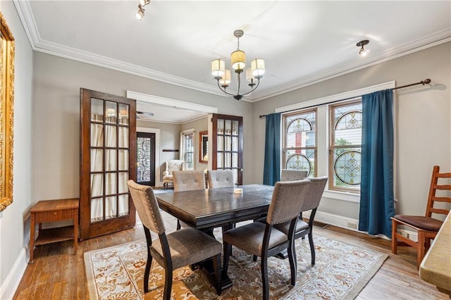 698 Bellemeade Ave NW, Atlanta, GA 30318 - dining room featuring a chandelier, crown molding, baseboards, and light wood-style flooring