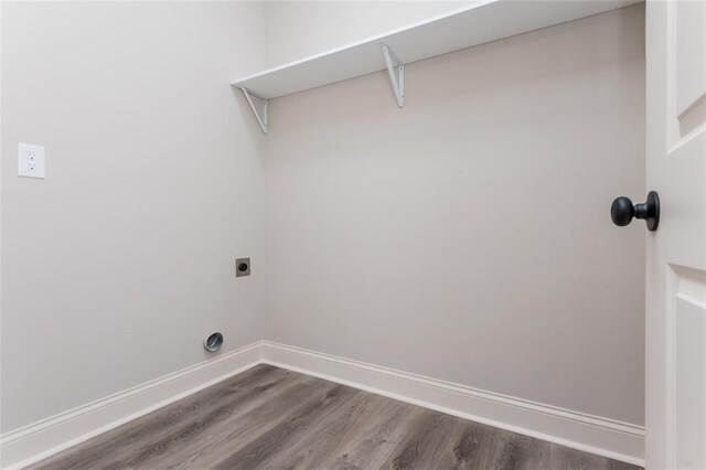 laundry area with dark wood finished floors, laundry area, baseboards, and electric dryer hookup