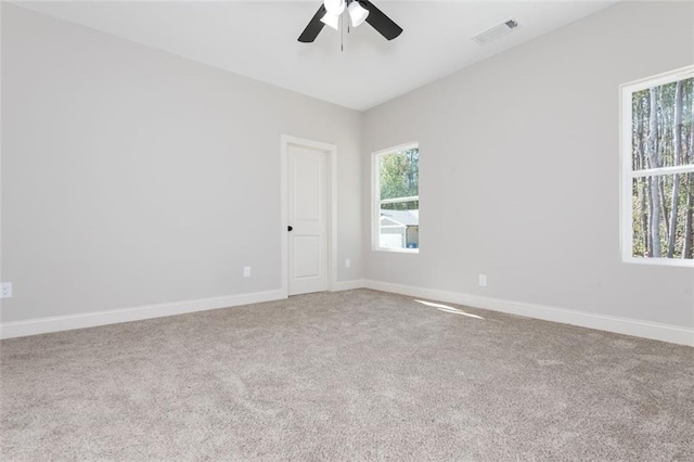 unfurnished room featuring carpet, baseboards, visible vents, and ceiling fan