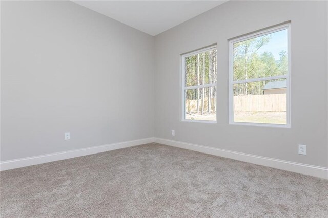 spare room with baseboards and carpet