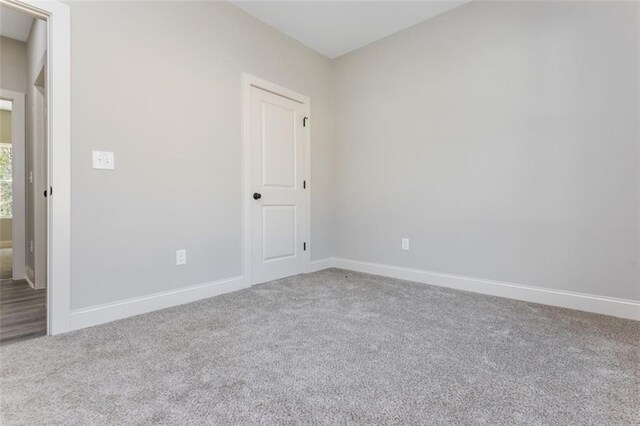 unfurnished room featuring carpet flooring and baseboards