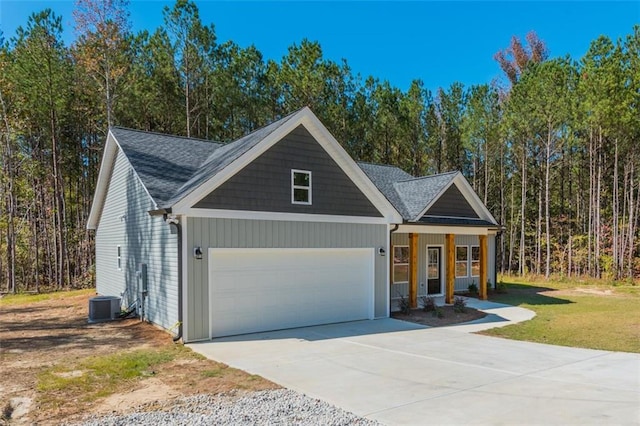 view of front of property featuring driveway, a porch, a front lawn, a garage, and central air condition unit