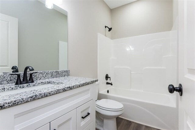 full bathroom featuring vanity,  shower combination, toilet, and wood finished floors