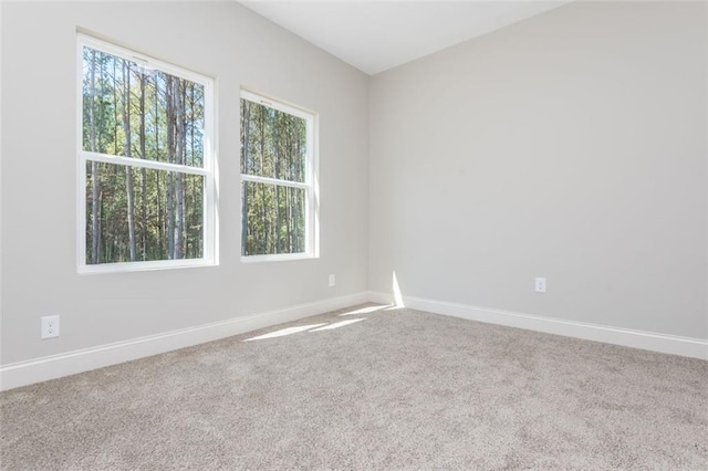 carpeted spare room featuring baseboards