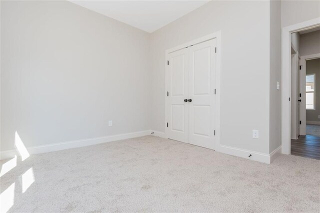 unfurnished bedroom featuring a closet, baseboards, and carpet