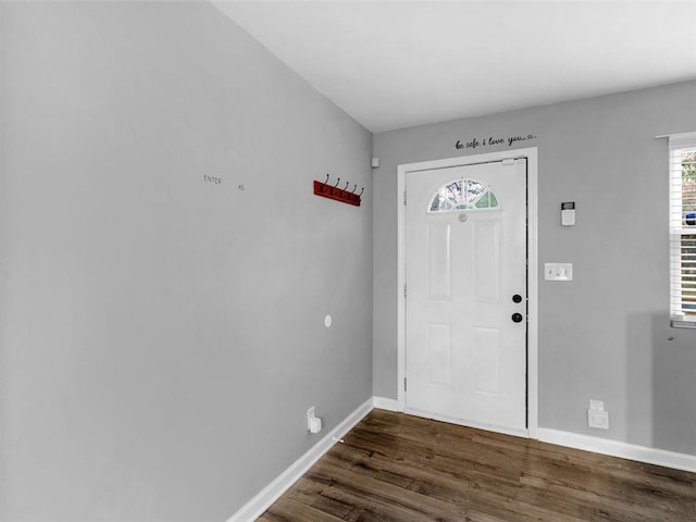 foyer featuring dark wood-type flooring and baseboards