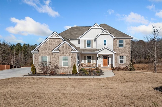 craftsman-style home featuring covered porch and a front lawn