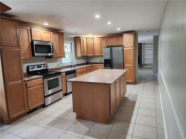 kitchen with sink, a center island, appliances with stainless steel finishes, and light tile patterned floors