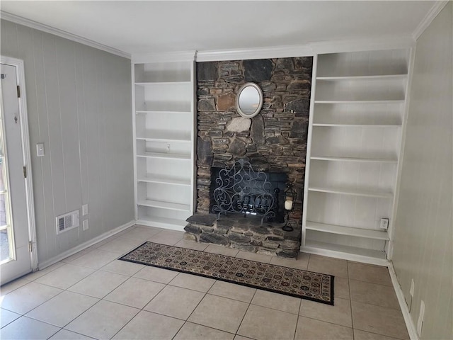 unfurnished living room featuring wood walls, a fireplace, built in features, ornamental molding, and light tile patterned floors