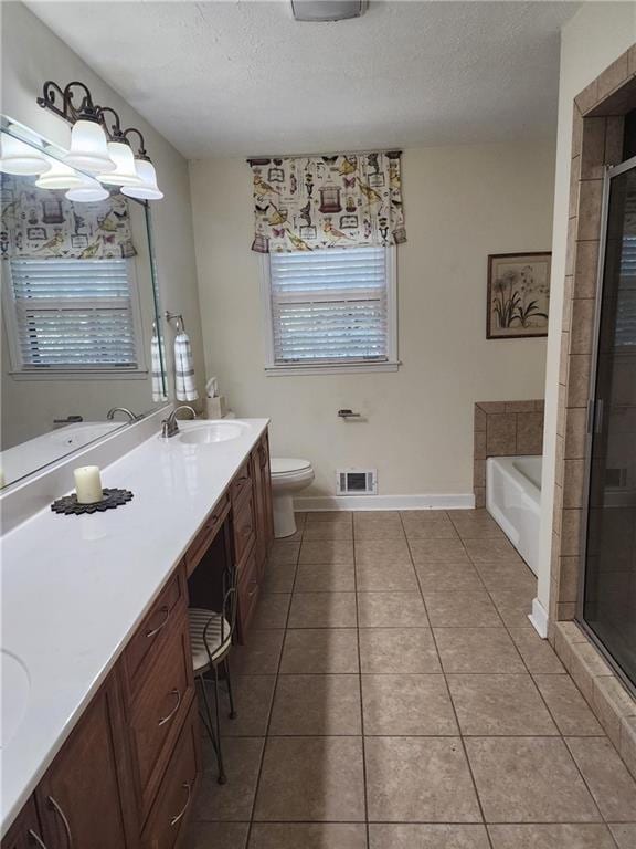 full bathroom featuring separate shower and tub, a textured ceiling, toilet, vanity, and tile patterned flooring