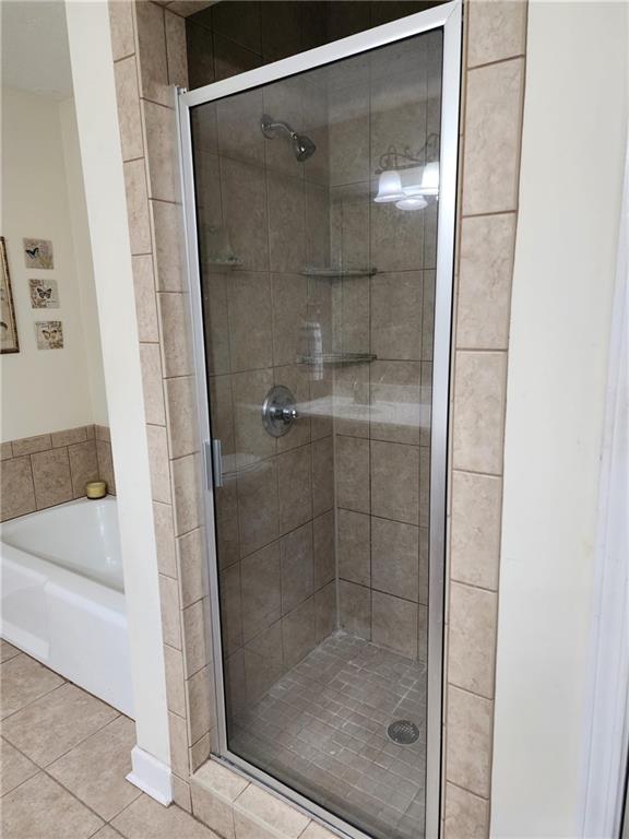 bathroom featuring plus walk in shower and tile patterned flooring