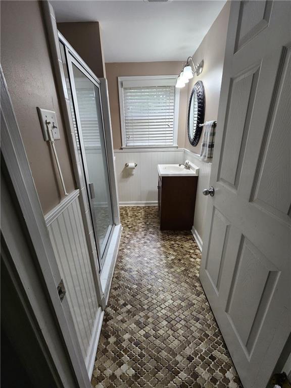 bathroom with vanity and a shower with shower door