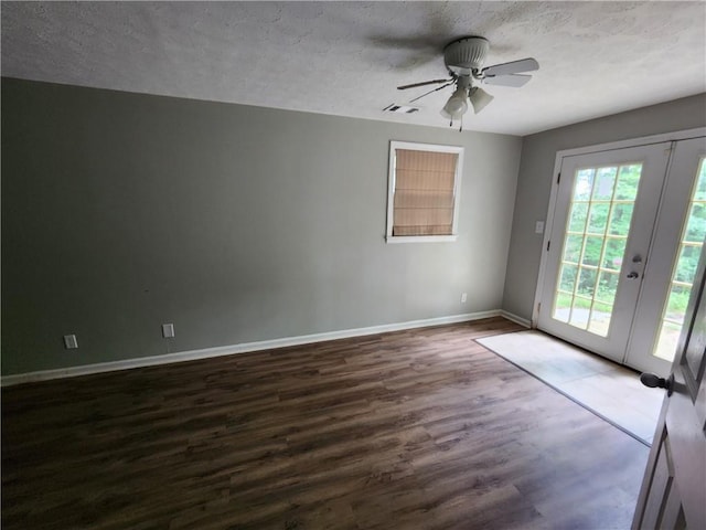 unfurnished room with french doors, dark wood-type flooring, and a textured ceiling