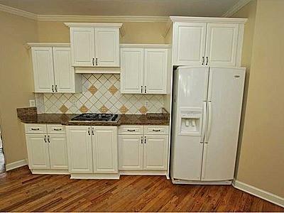 kitchen with white refrigerator with ice dispenser, white cabinets, gas stovetop, and dark hardwood / wood-style floors