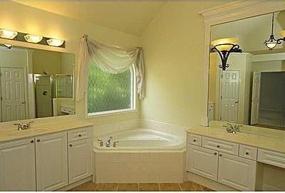 bathroom featuring dual vanity, shower with separate bathtub, tile flooring, and vaulted ceiling