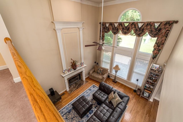 living room featuring plenty of natural light, light hardwood / wood-style floors, ornamental molding, and ceiling fan