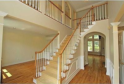 staircase featuring a high ceiling, hardwood / wood-style floors, and decorative columns