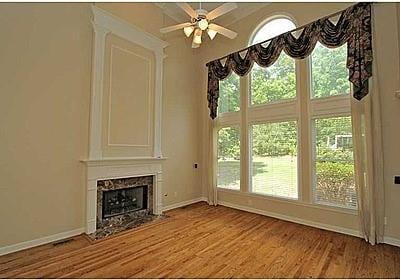 unfurnished living room featuring a premium fireplace, wood-type flooring, and ceiling fan