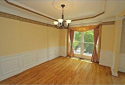 unfurnished room with an inviting chandelier, ornamental molding, a tray ceiling, and light wood-type flooring