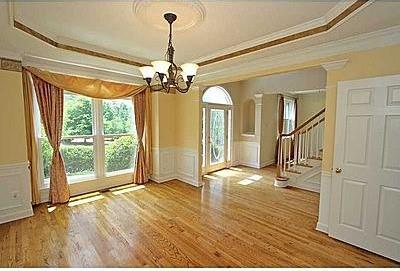 unfurnished room featuring light hardwood / wood-style flooring, ornamental molding, a chandelier, and a raised ceiling