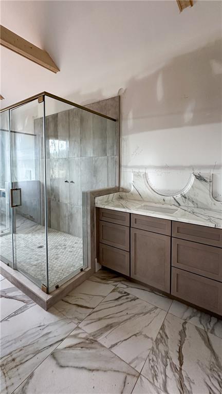 full bathroom with marble finish floor, a stall shower, and vanity