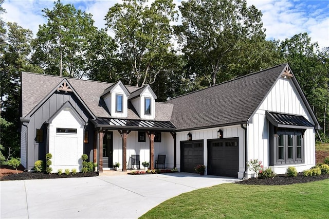 modern farmhouse featuring a standing seam roof, board and batten siding, an attached garage, a shingled roof, and metal roof