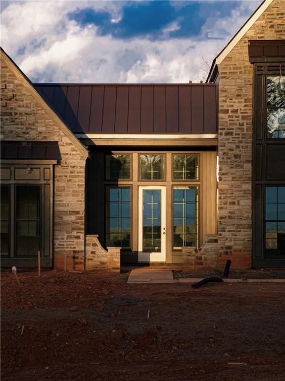 property entrance with a standing seam roof, stone siding, and metal roof