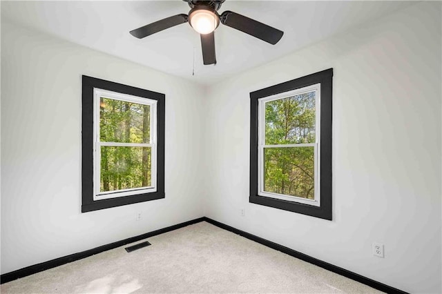 empty room with visible vents, baseboards, carpet flooring, and ceiling fan