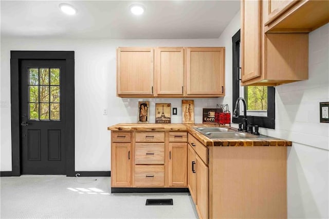 kitchen with light brown cabinetry, a sink, plenty of natural light, and recessed lighting