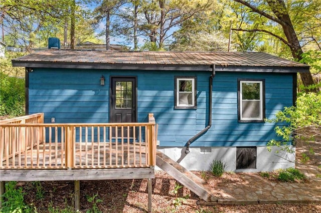 rear view of house featuring metal roof and a wooden deck