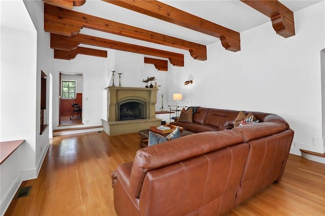4043 Piedmont Lake Rd, Pine Mountain, GA 31822 - living area featuring beamed ceiling, light wood-type flooring, a fireplace with raised hearth, and baseboards