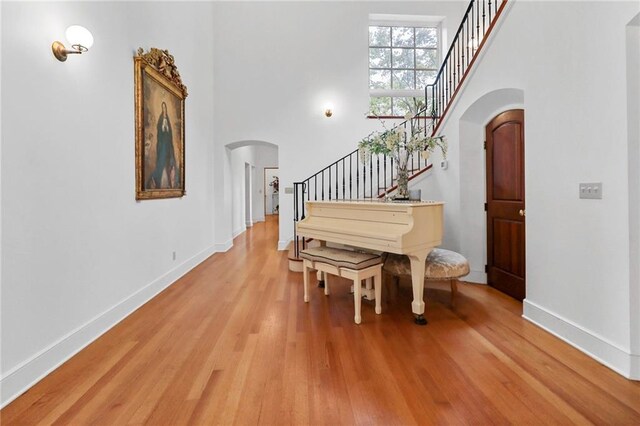4043 Piedmont Lake Rd, Pine Mountain, GA 31822 - entrance foyer with arched walkways, stairway, light wood-style floors, a towering ceiling, and baseboards