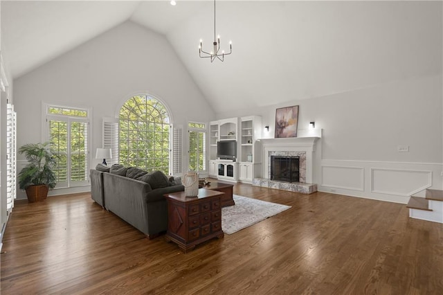 3260 Kingshouse Commons, Johns Creek, GA 30022 - living area with a chandelier, a high end fireplace, wood finished floors, high vaulted ceiling, and wainscoting