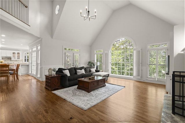 3260 Kingshouse Commons, Johns Creek, GA 30022 - living area featuring high vaulted ceiling, dark wood-style floors, a chandelier, and wainscoting