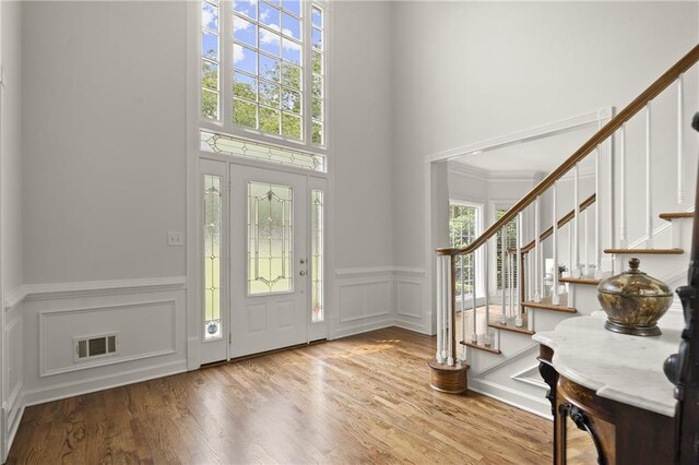 3260 Kingshouse Commons, Johns Creek, GA 30022 - foyer entrance with a decorative wall, stairway, a towering ceiling, wood finished floors, and wainscoting