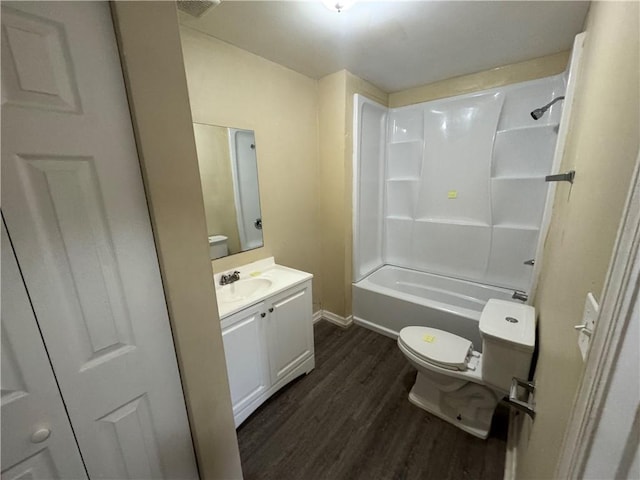 full bathroom with hardwood / wood-style flooring, vanity, tub / shower combination, and toilet