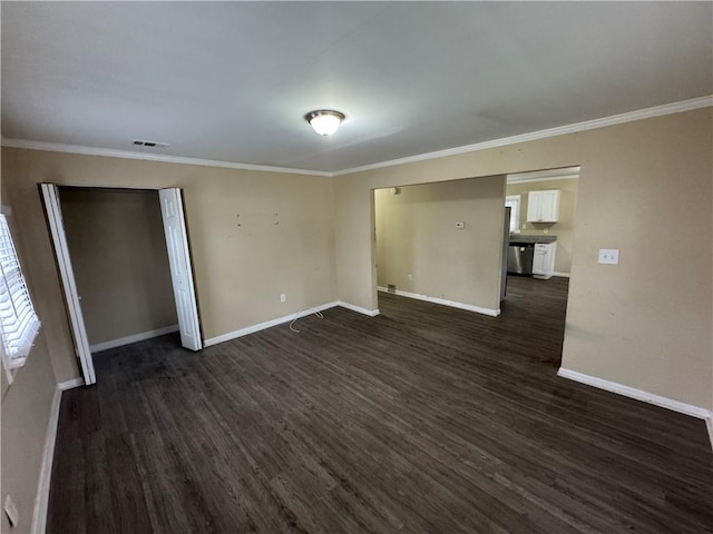 empty room featuring ornamental molding and dark hardwood / wood-style flooring