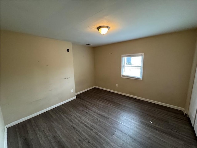 spare room with dark wood-type flooring