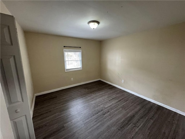 empty room with dark hardwood / wood-style flooring