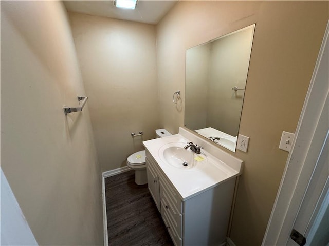 bathroom with vanity, toilet, and hardwood / wood-style floors