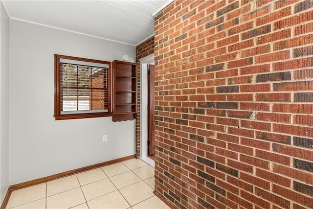 spare room featuring light tile patterned floors and baseboards