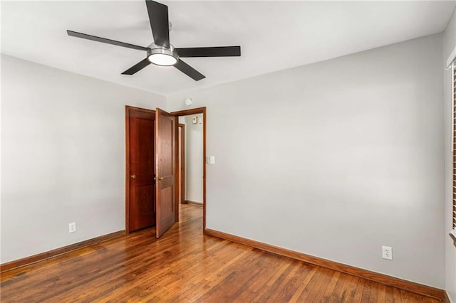 empty room featuring baseboards, wood-type flooring, and ceiling fan