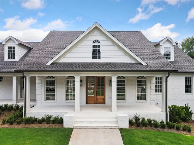 view of front of home with a front lawn, french doors, and a porch