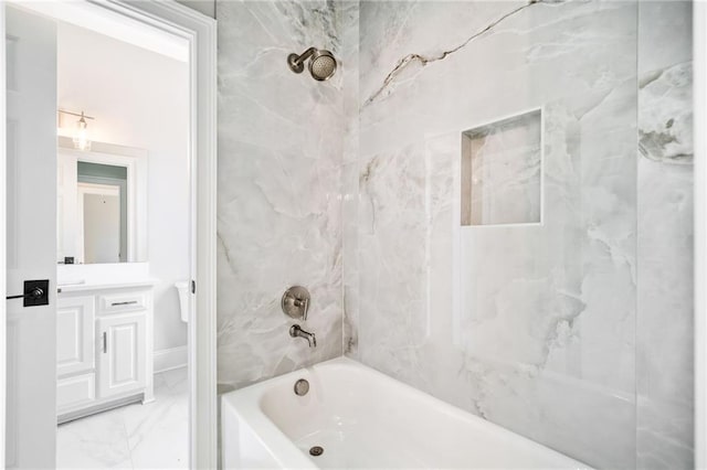 bathroom with tiled shower / bath combo and vanity