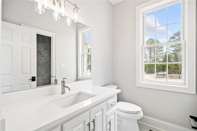 bathroom with vanity, toilet, and a notable chandelier