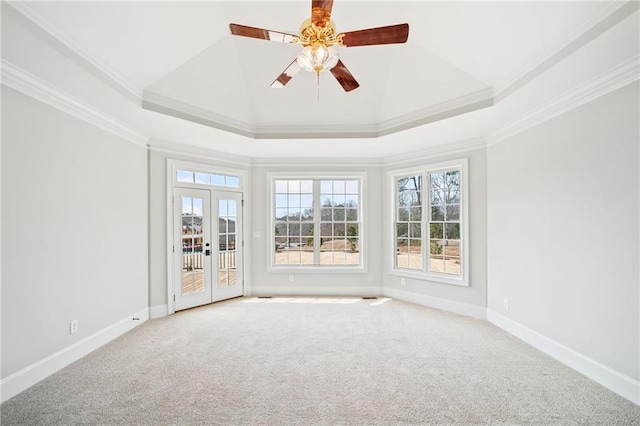 unfurnished room with carpet flooring, crown molding, a tray ceiling, and french doors