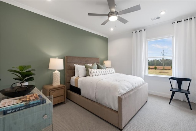 carpeted bedroom with ornamental molding and ceiling fan